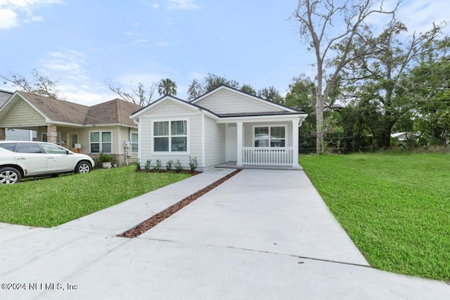 view of front of home with covered porch and a front lawn