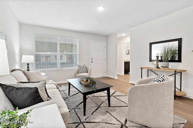 living room featuring a textured ceiling and light wood-type flooring