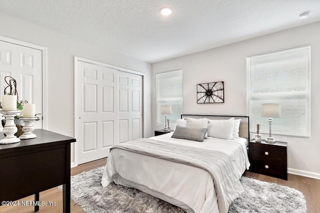 bedroom featuring a textured ceiling, a closet, and dark wood-type flooring