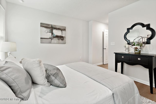 bedroom with dark hardwood / wood-style flooring