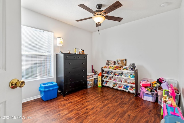 game room with dark hardwood / wood-style floors and ceiling fan