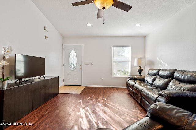 living room with a textured ceiling, light hardwood / wood-style floors, and ceiling fan