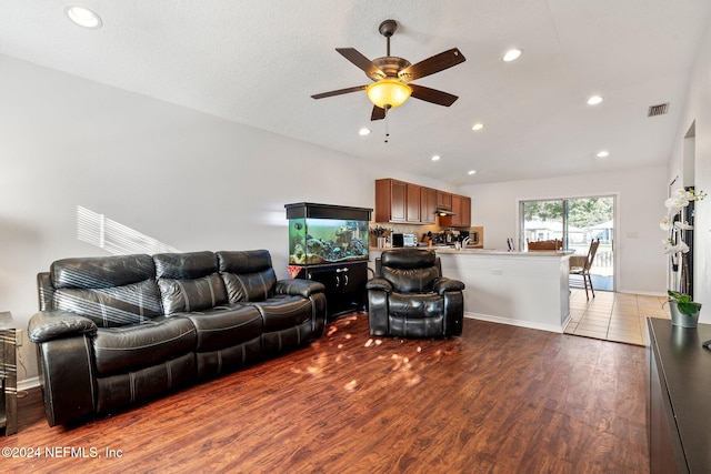 living room featuring ceiling fan, wood-type flooring, and a textured ceiling