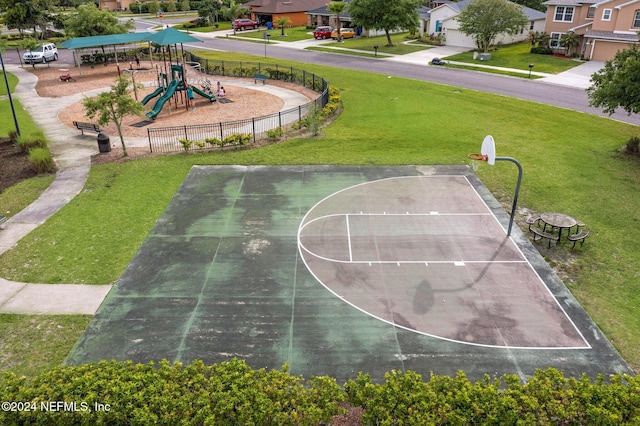 view of basketball court with a playground and a lawn