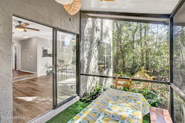 unfurnished sunroom with ceiling fan