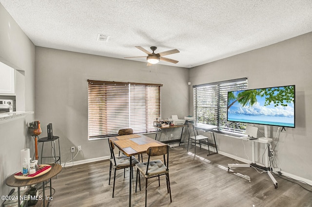 dining space featuring a textured ceiling, ceiling fan, and dark hardwood / wood-style floors