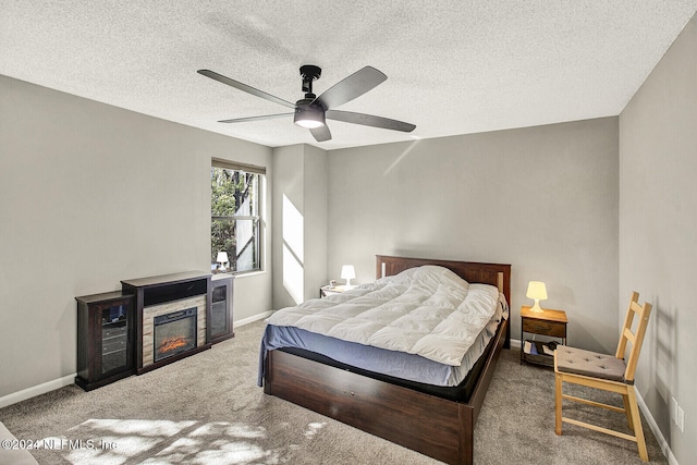 bedroom with ceiling fan, a fireplace, carpet, and a textured ceiling