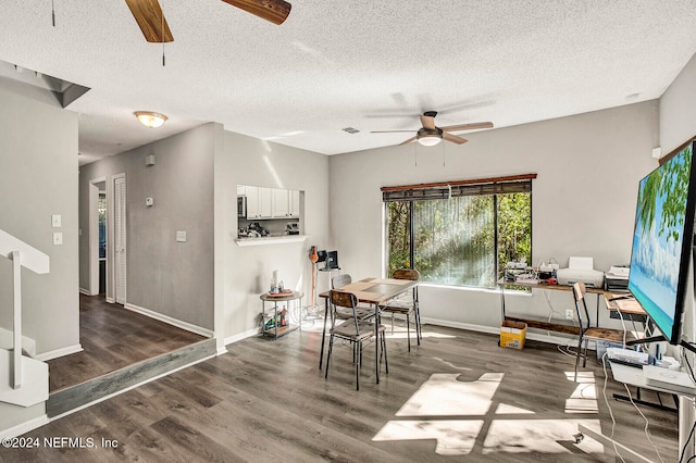 dining room with a textured ceiling and dark wood-type flooring