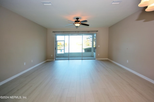 empty room with ceiling fan and light hardwood / wood-style floors