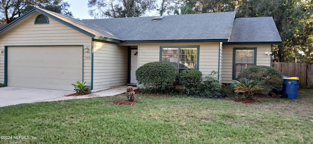 single story home featuring a garage and a front lawn