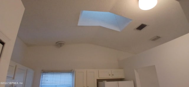 interior details featuring a skylight and fridge