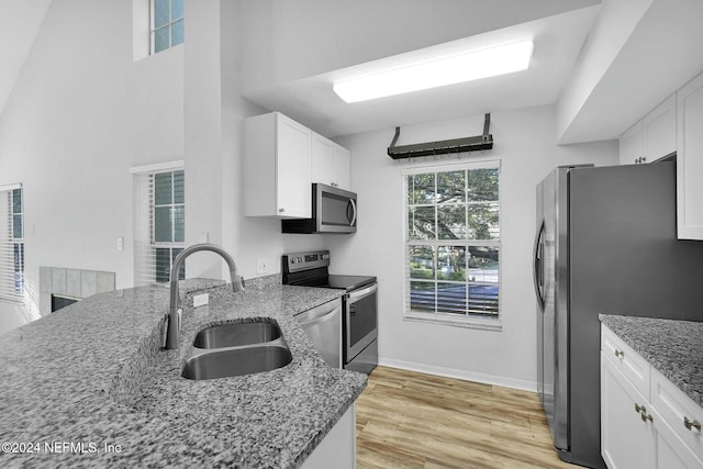 kitchen with white cabinets, light hardwood / wood-style floors, stainless steel appliances, and sink