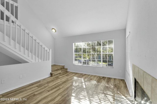 unfurnished living room with hardwood / wood-style floors and vaulted ceiling