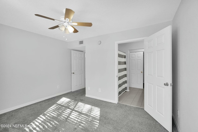 unfurnished bedroom with carpet floors and ceiling fan