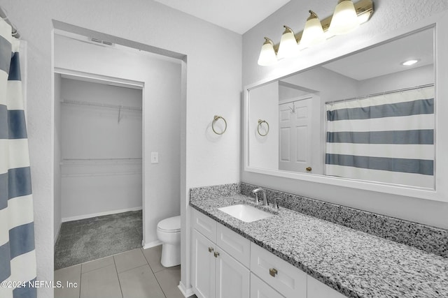 bathroom featuring tile patterned floors, vanity, and toilet