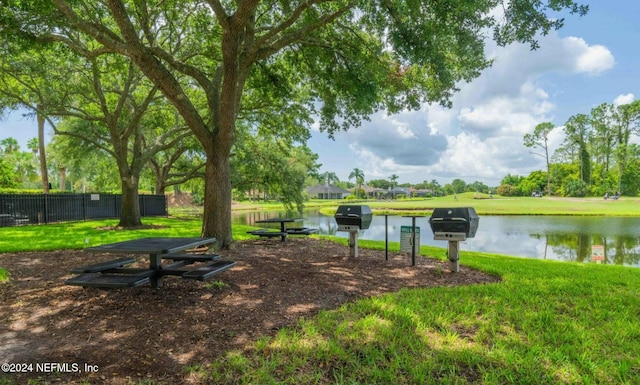 surrounding community featuring a water view and a lawn