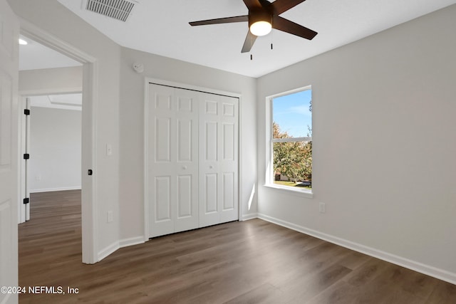 unfurnished bedroom featuring dark hardwood / wood-style floors, ceiling fan, and a closet