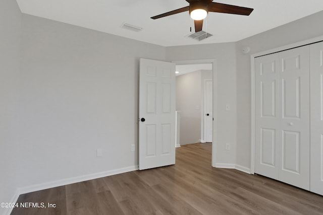 unfurnished bedroom featuring ceiling fan, a closet, and light hardwood / wood-style flooring