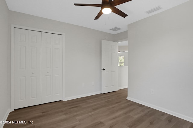 unfurnished bedroom featuring ceiling fan, a closet, and hardwood / wood-style flooring