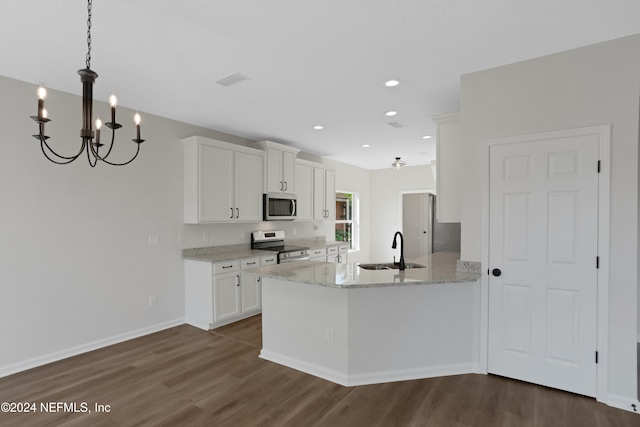 kitchen with sink, dark hardwood / wood-style flooring, kitchen peninsula, white cabinets, and appliances with stainless steel finishes