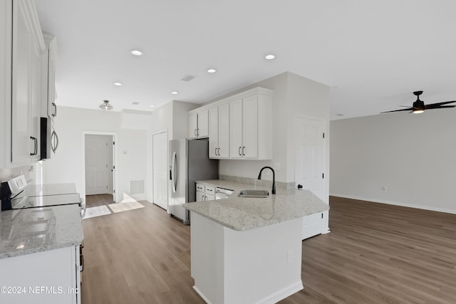 kitchen with white cabinets, light stone countertops, and sink