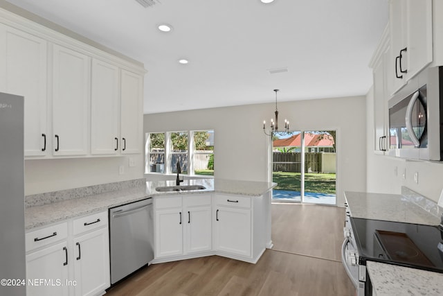 kitchen with sink, kitchen peninsula, light hardwood / wood-style floors, white cabinets, and appliances with stainless steel finishes