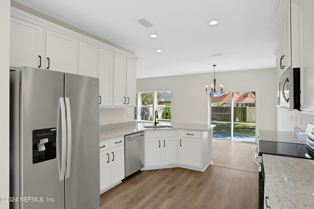 kitchen with white cabinets, light hardwood / wood-style floors, sink, and appliances with stainless steel finishes