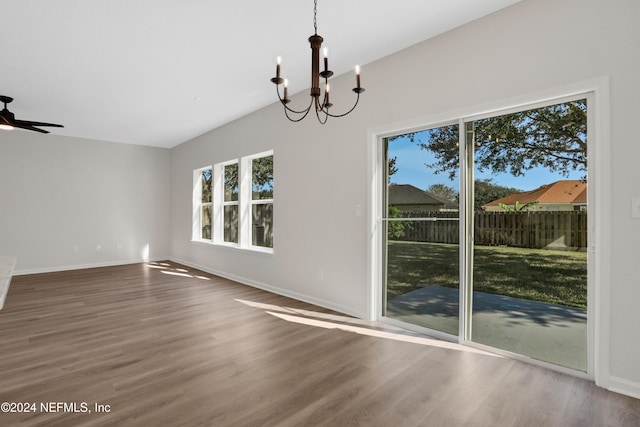 unfurnished dining area featuring ceiling fan with notable chandelier and hardwood / wood-style flooring