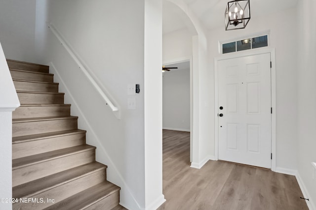 foyer with ceiling fan with notable chandelier and light hardwood / wood-style floors