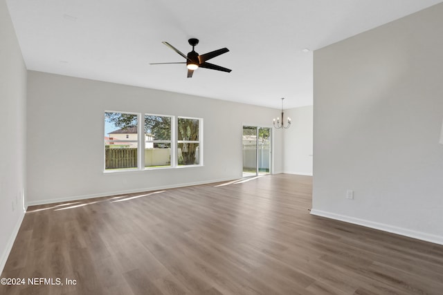 unfurnished living room with dark hardwood / wood-style floors and ceiling fan with notable chandelier