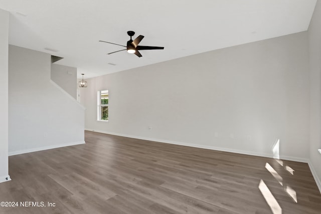 unfurnished room featuring ceiling fan with notable chandelier and hardwood / wood-style flooring