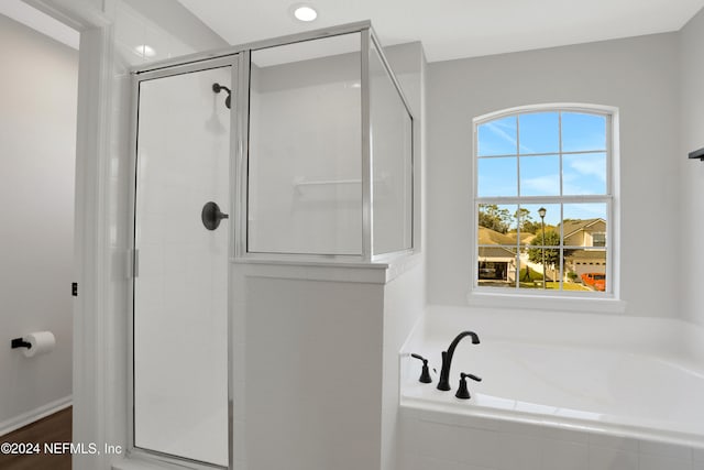 bathroom featuring independent shower and bath