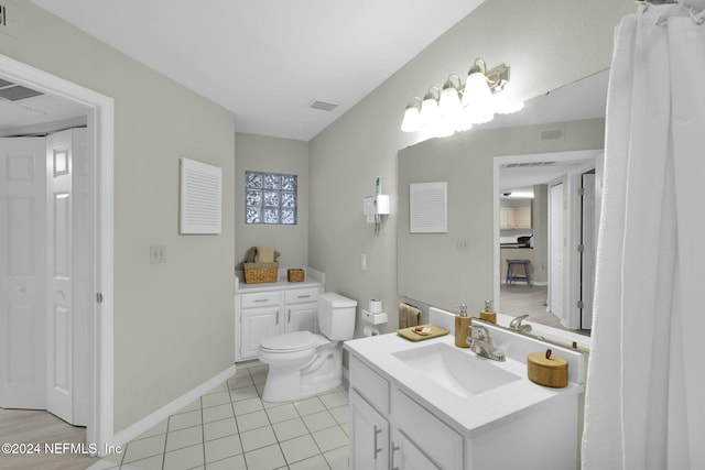 bathroom with tile patterned flooring, vanity, and toilet