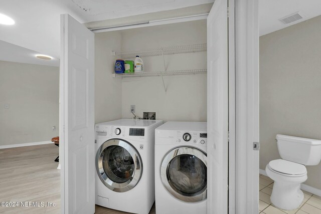 washroom with separate washer and dryer and light tile patterned floors