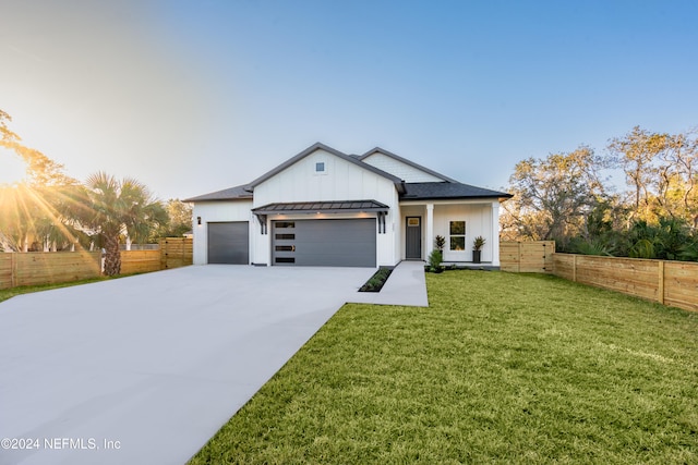 modern inspired farmhouse with a garage and a front lawn