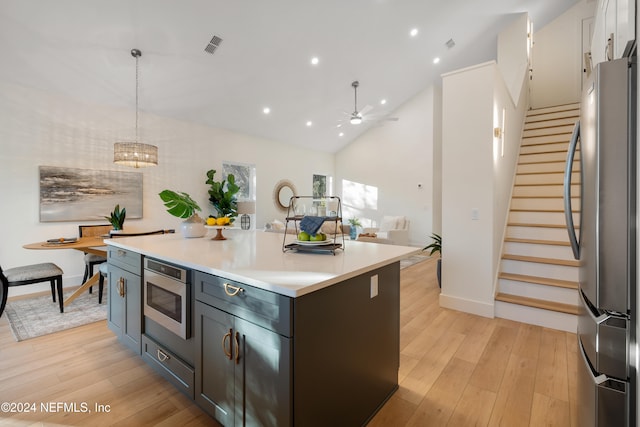 kitchen featuring a center island, ceiling fan, decorative light fixtures, light hardwood / wood-style floors, and stainless steel appliances