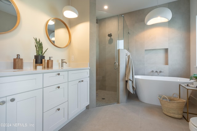 bathroom featuring shower with separate bathtub, vanity, and tile patterned floors