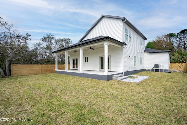 back of property featuring a lawn, ceiling fan, french doors, and a patio