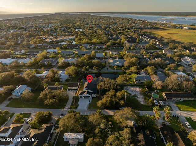 aerial view at dusk featuring a water view