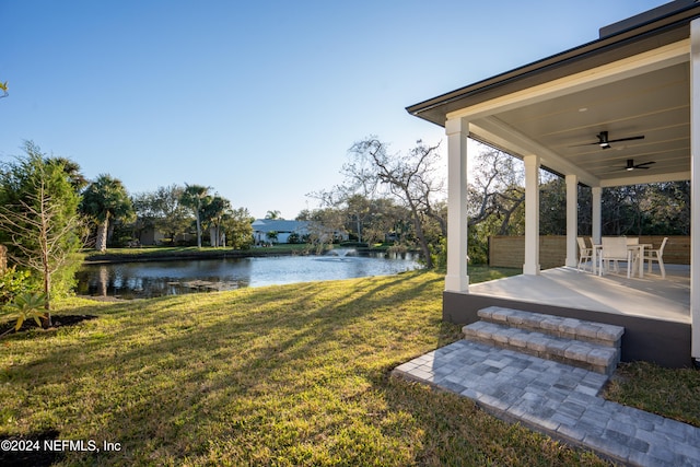 view of yard featuring a patio, a water view, and ceiling fan