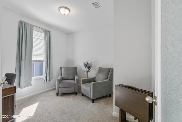 sitting room featuring light colored carpet