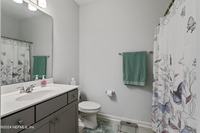 bathroom featuring tile patterned floors, curtained shower, vanity, and toilet