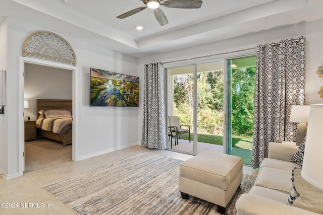 interior space with light tile patterned floors, a raised ceiling, and ceiling fan