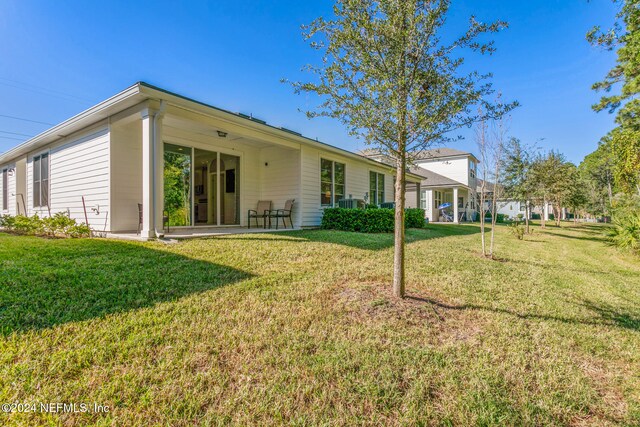 rear view of house featuring a yard