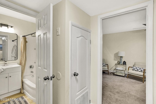 bathroom with shower / bath combo with shower curtain and vanity