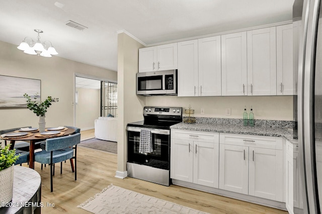 kitchen with white cabinets, stainless steel appliances, a notable chandelier, and light wood-type flooring