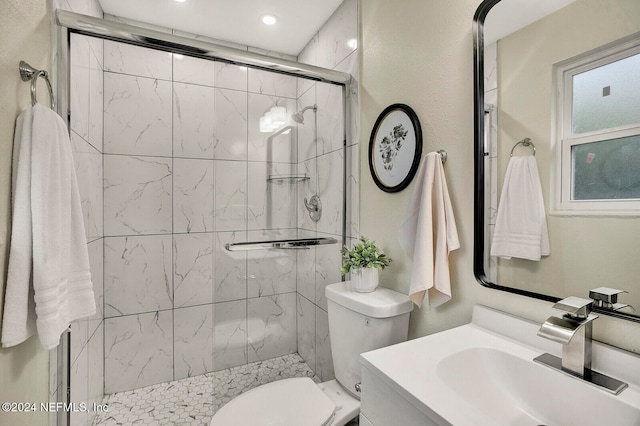 bathroom featuring a shower with door, vanity, and toilet