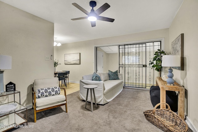 living room with carpet and ceiling fan with notable chandelier