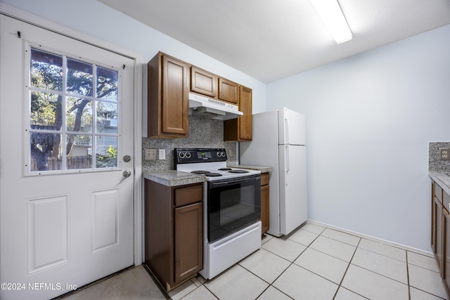 kitchen with decorative backsplash, light tile patterned flooring, and white appliances