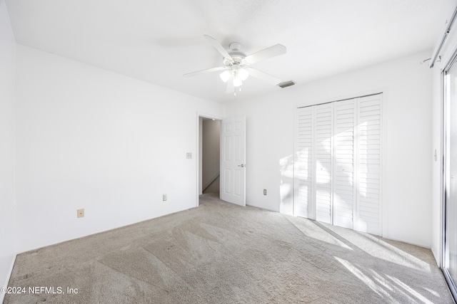 unfurnished bedroom with multiple windows, light colored carpet, a closet, and ceiling fan